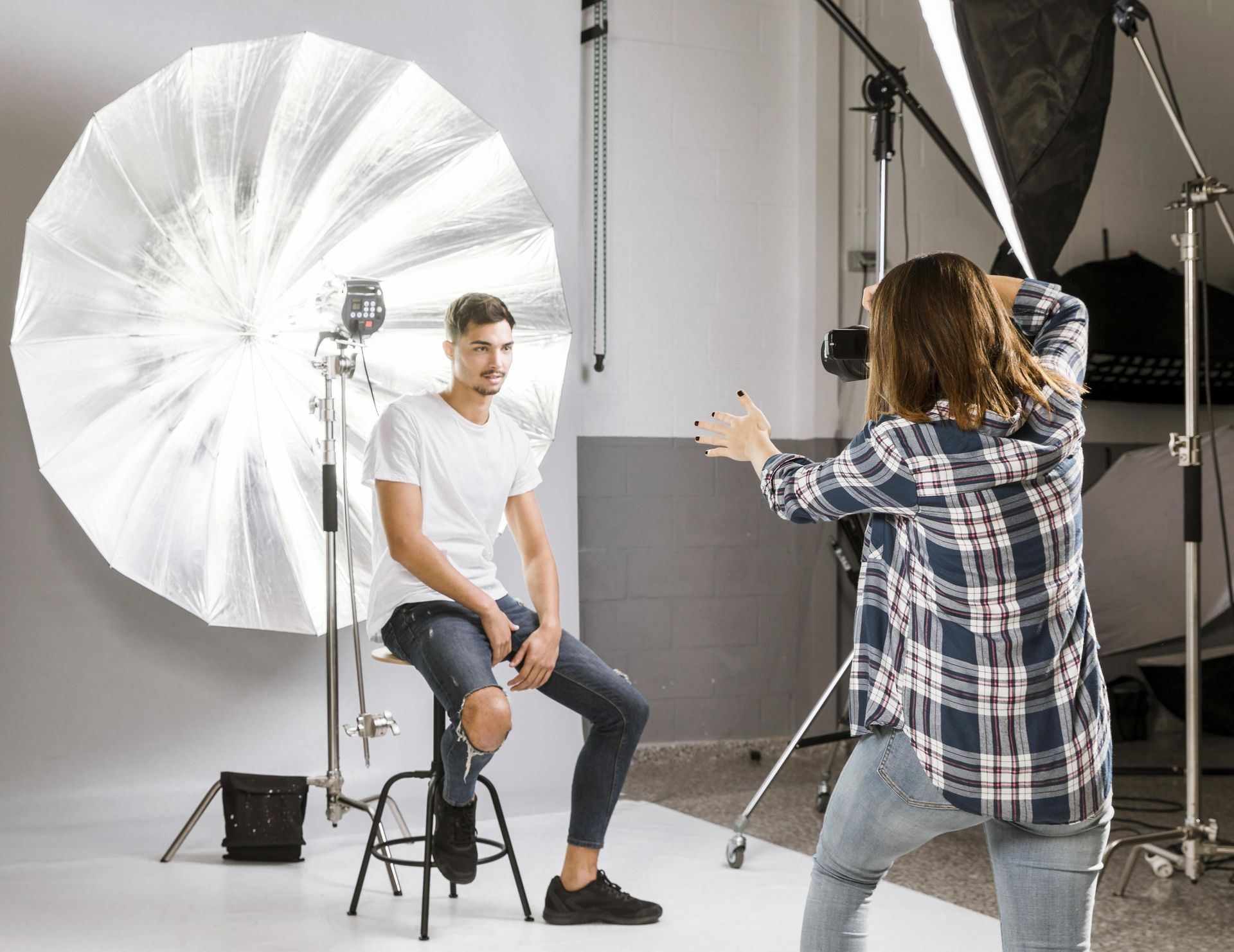 photographer taking photos of male in studio