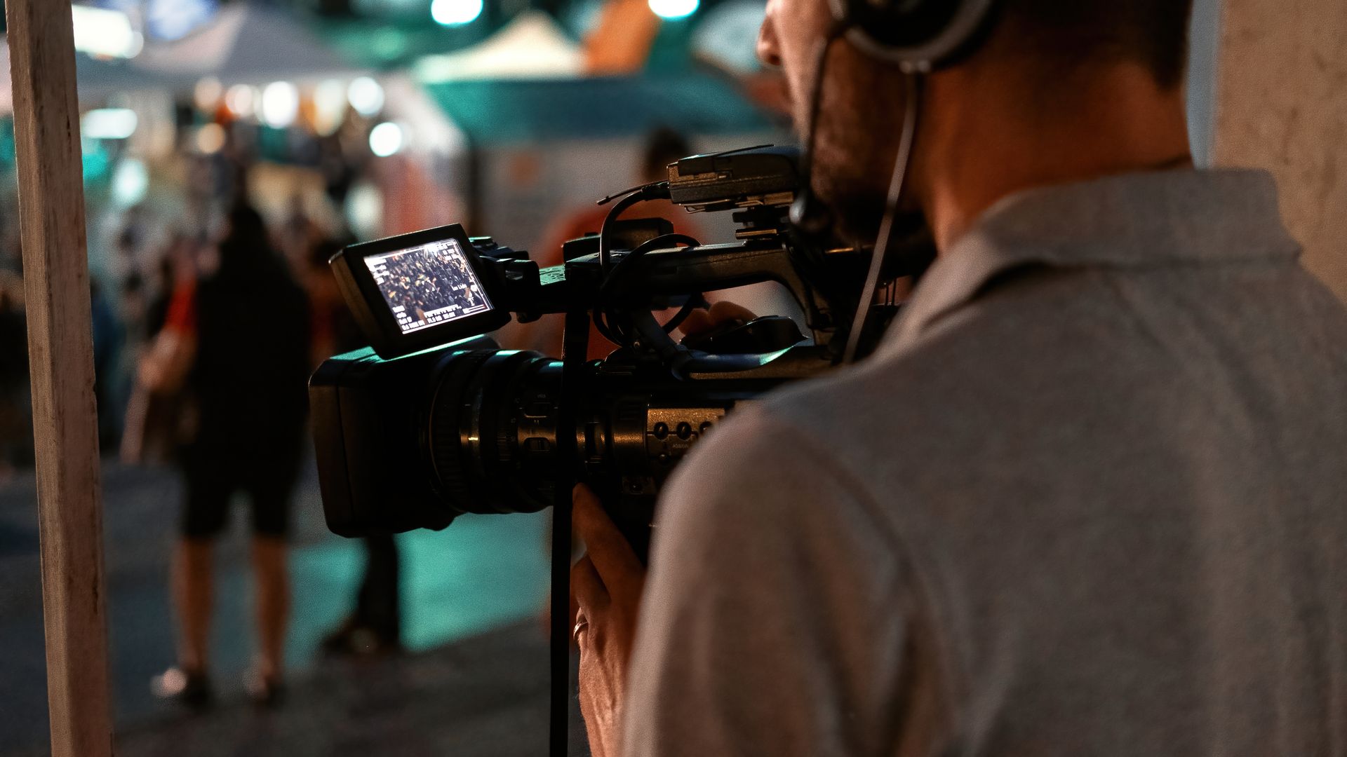 man recording a football game at night