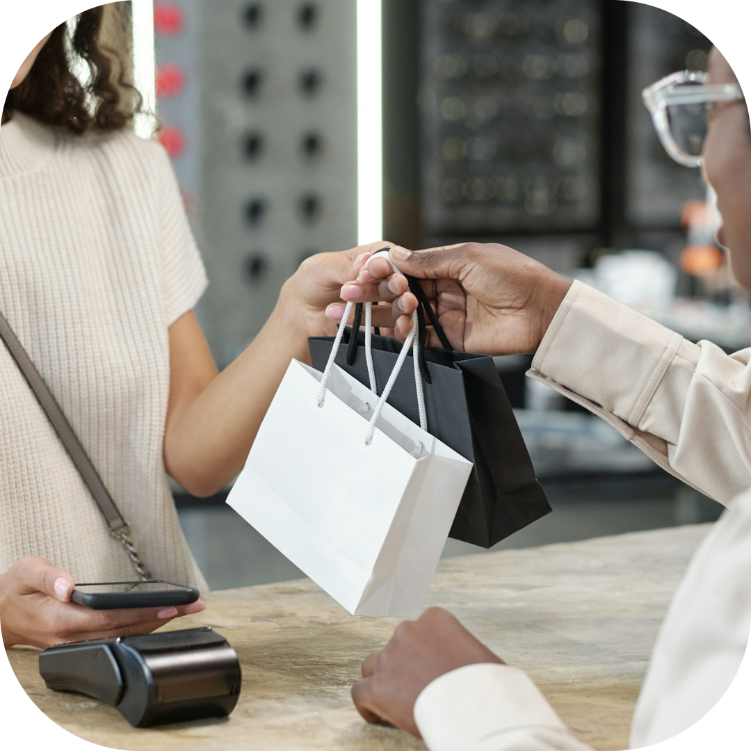 employee handing the customer her bags at check out