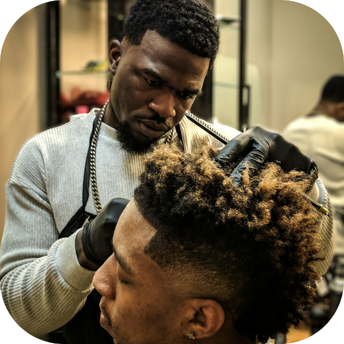 customer getting a hair cut by his barber