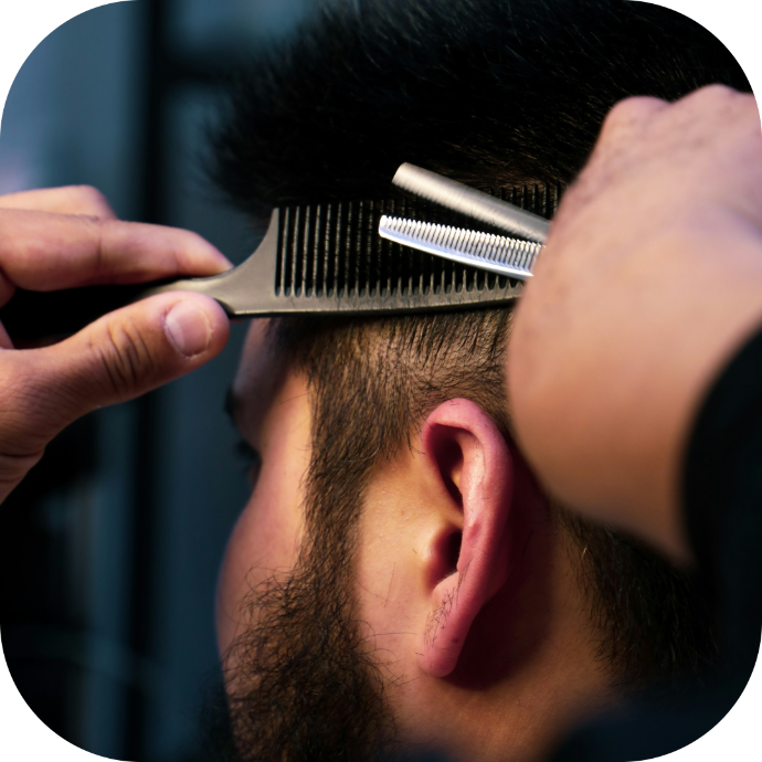 barber giving a hair cut to his client in the chair